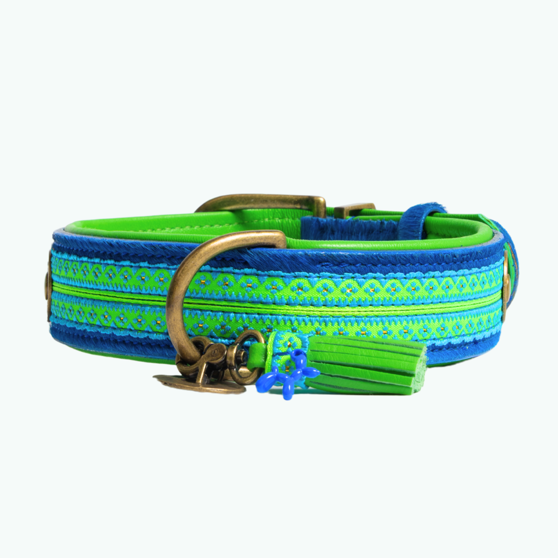Zula hondenhalsband close-up, kobaltblauwe vacht met neongroene bohemian band, bronzen D-ring en groen leren kwastje