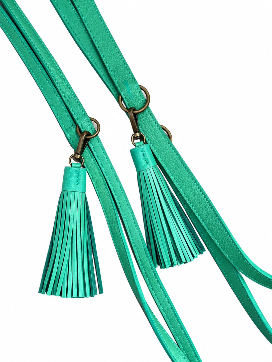 Twee turquoise leren Free Spirit hondenriemen (maat M en L) van Dog with a Mission met bronskleurige sluitingen, verstelringen en een leren kwastje